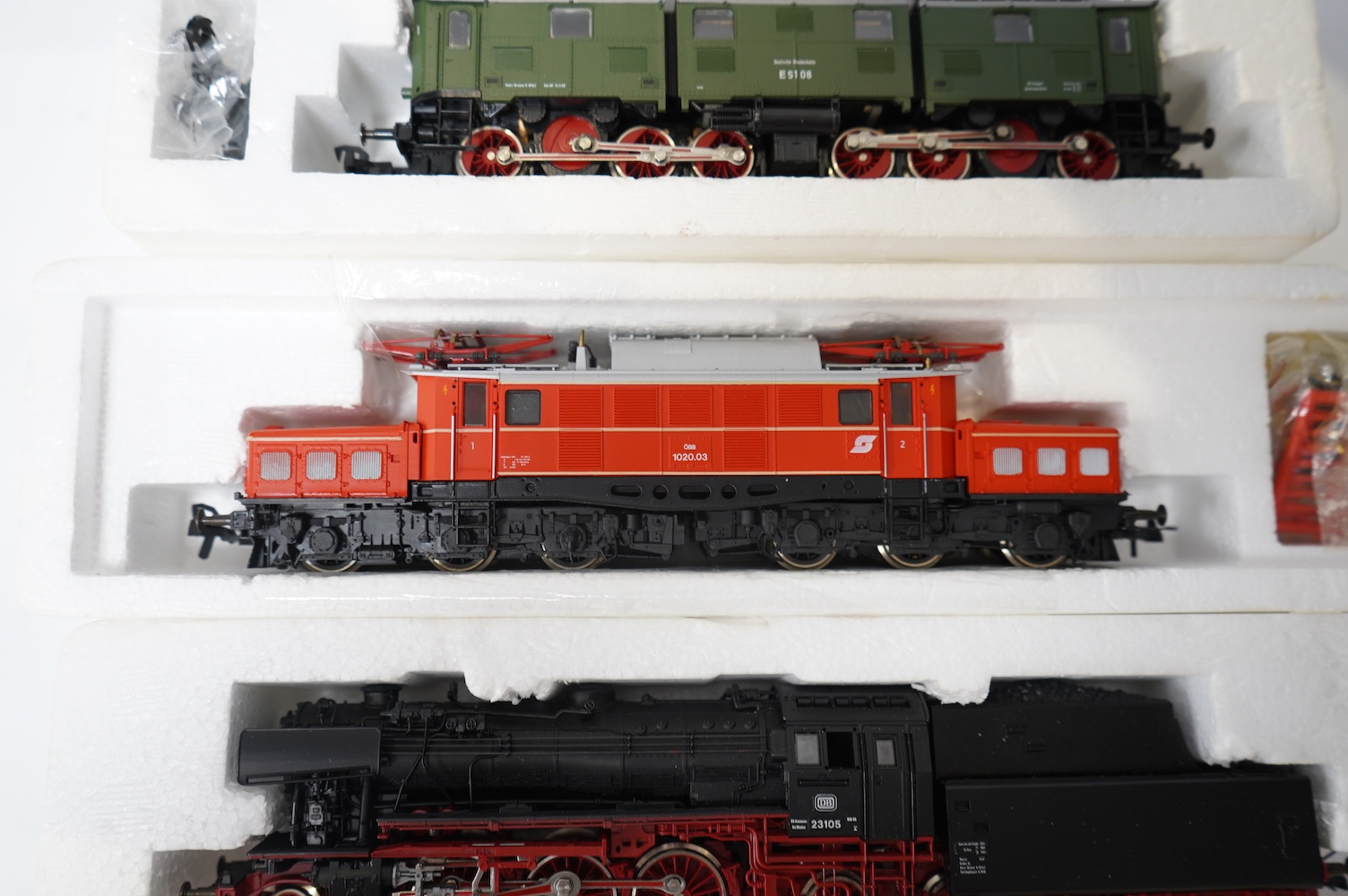 Three boxed RoCo HO gauge railway German locomotives; a DB 2-6-2 tender loco (04120A), a DB articulated pantograph electric loco (04139S), and a OBB Co-Co pantograph electric loco (04169B). Condition - good.